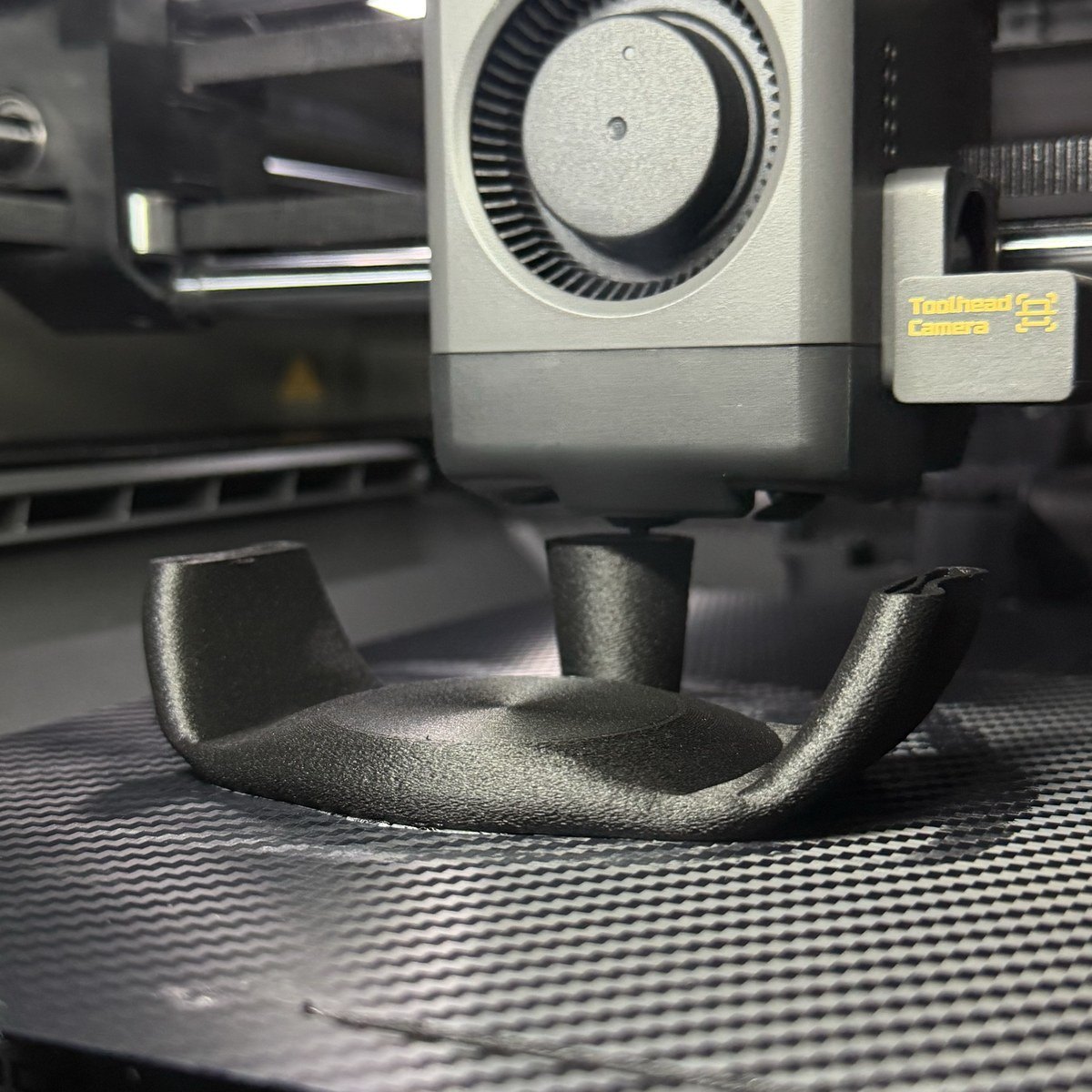 A finished Rockstar Health joystick topper sitting on the printer bed under the toolhead.